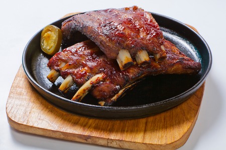 Tasty grilled ribs with vegetables on a panの写真素材