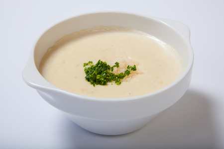 delicious creamy soup with parasley and cheese on white dish. Isolatedの写真素材