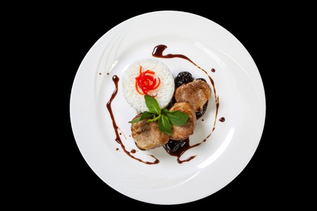 Pork medallions steak with prunes sauce on a white plate.の写真素材