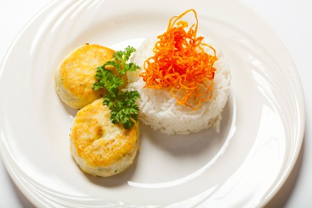 cutlets with herbs and rice on a plate. White background.の写真素材