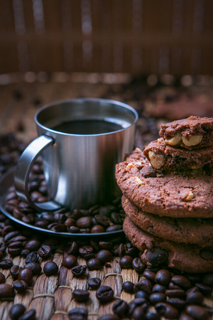 coffee cup and coffee beans on wooden table with cookies.の写真素材