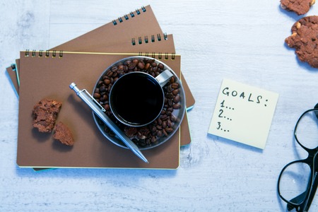Blank spiral notepads, Cup of Coffee and Pen on Wood Background.の写真素材