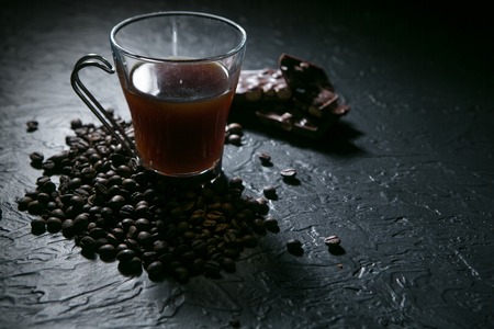 coffee cup and coffee beans on black background.