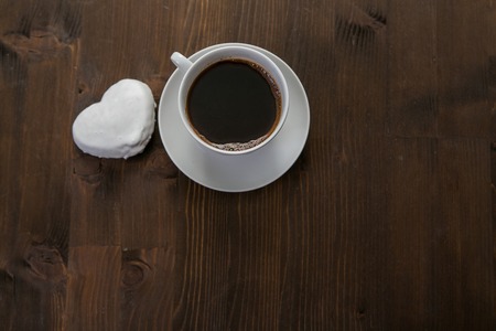 white coffee cup and gingerbread on wooden desk.の写真素材