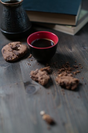 coffee Cup and cookies are next to the stack of books.の写真素材