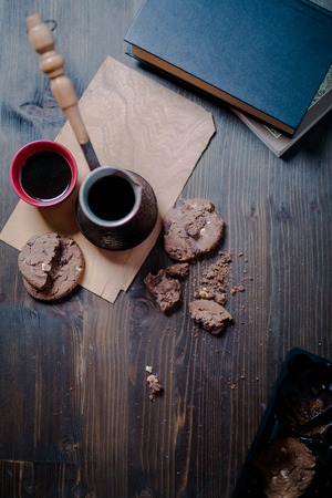 coffee Cup and cookies and coffee maker are on the wooden table next to the book.の写真素材