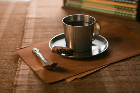 coffee Cup with spoon and biscuits on the background of notebooks.の写真素材