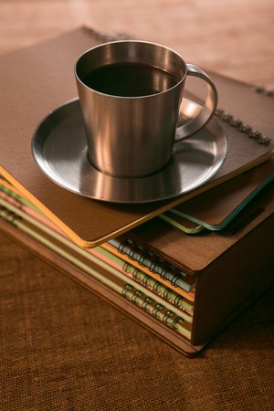 coffee Cup with cookies is on the stack of notebooks.の写真素材