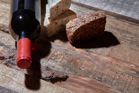 Red wine and ingredients for romantic dinner on the wooden background. Cheese and bread. Imageの写真素材