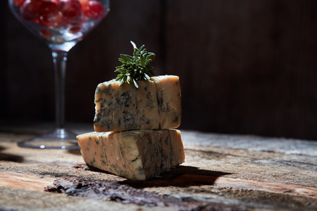 Layout of wineglass with grapes on wooden table with blue cheeseの写真素材