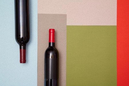 Layout of bottles of red wine on colorful paper backgroundの写真素材