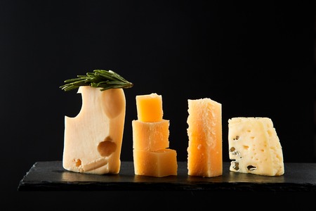 Different sorts of cheese on the black background. Studio Image.