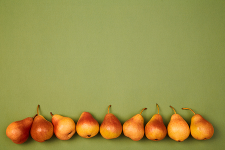 Colorful fruit pattern or background. Ripe fresh juicy pears placed on green background.の写真素材