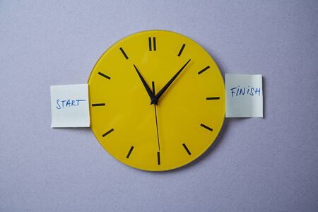 Time management deadline and schedule concept: yellow clock covered with stickers.