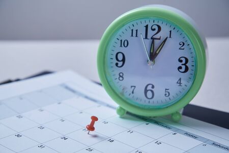 Time management, deadline and schedule concept: alarm clock and notebook on blue background
