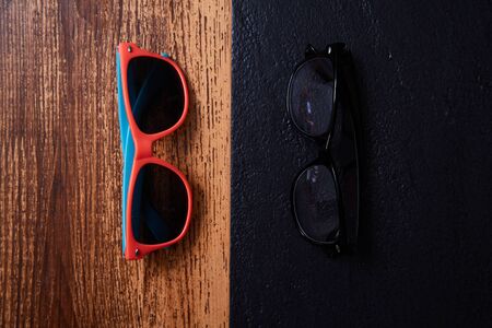 Work life balance choice concept: colored sunglasses and strict office glassesの写真素材