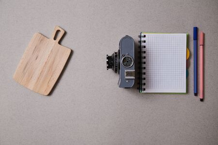 Food blogging, blog and blogger or social media concept: notepad and a retro photo camera on a grey background. Flat lay.の写真素材