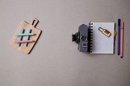 Food blogging, blog and blogger or social media concept: symbol hashtag, notepad and a retro photo camera on a grey background. Flat lay.の写真素材