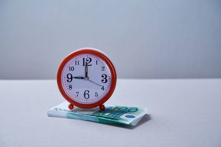 Euro banknote with clock on grey background composition. Concept for time money or bank loan