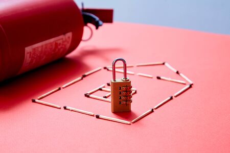 Fire safety or security and protection concept. A fire extinguisher, the figure of the house and lock.の写真素材