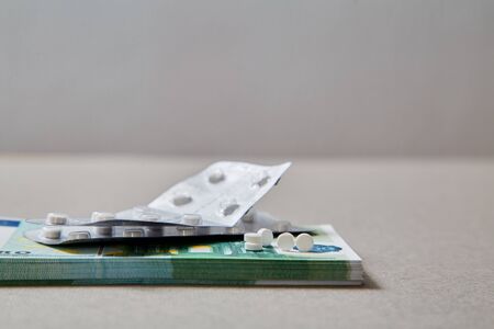 Concept for expensive health care,pharmaceutical and paid medicine. Tablets lying on a pack of...