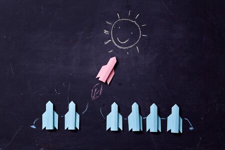 Business career, success and individuality concept. Solution, rivalry and challenge. Rocket flying towards the sunの写真素材