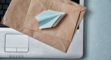Sending e-mails and e-commerce business. Email marketing or advertising: paper airplanes, envelopes and a laptopの写真素材