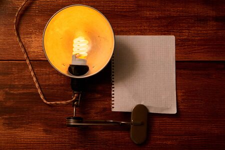 Vintage lamp and a piece of paper for writing on a wooden background. Mock upの写真素材
