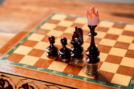 Chess game, leadership and competition concept. Chess king in a paper crown