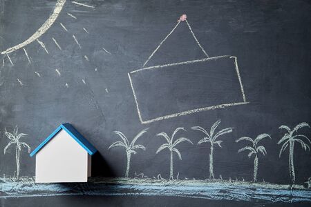 House rent. Booking accommodation in advance. Summer vacation and travel concept. Chalk board with seasonal objects. Palm trees housing mockup ocean. Sign with copy spaceの写真素材