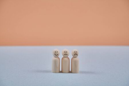 Emotions of people. Positive, negative, neutral attitude. Wooden persons figures with smile, sad and...