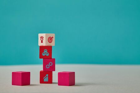 Business growth and development. Efficiency and strategy. Wooden red blocks stack with white on top....