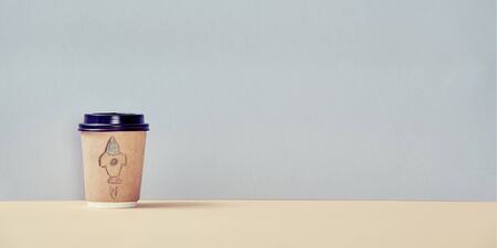 Paper cup with rocket painting. Creative start-up. Copy space in right side. Mockup style. Self development conceptの写真素材
