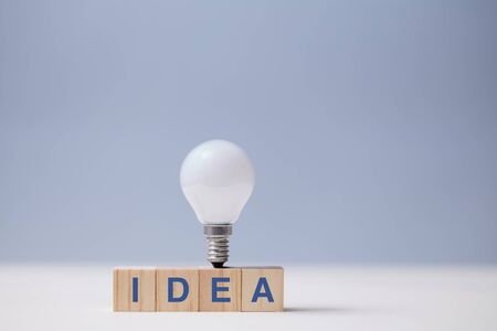 Creative idea generation. Creativity and innovation. Originative thinking. Wooden cubes, idea inscription and lightbulb.の写真素材