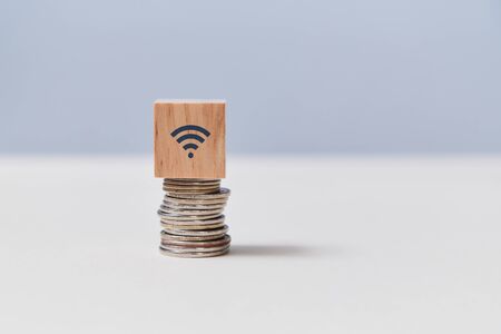 Online banking. Investment and trading. Financial services. Stack of coins and cube on top with wifi...
