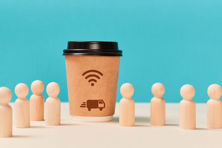 Express home delivery service. Online ordering food, drinks. Paper cup with wifi, truck sign. Wooden figure, copy spaceの写真素材