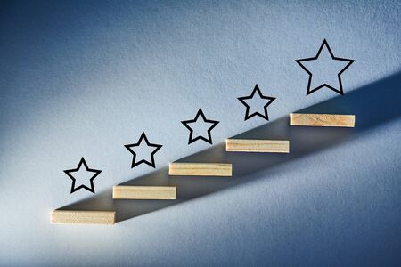 Rate service quality. Mark number of stars. Wooden sticks as staircase on blue backdrop. Customer...