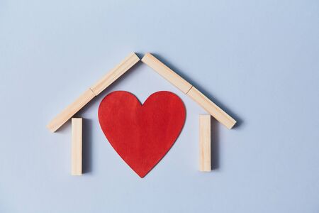 Relationship and happy family. Love or affection. Adopt child. Red heart and wooden blocks. Isolated on blue background.の写真素材