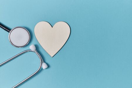 Heart disease and health mockup. White blank heart and stethoscope on blue background. Medicine and...