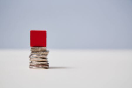 Pile of coins, red cube on top mockup, copy space. Template for creative design. Increase in income....