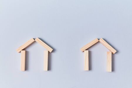 Wooden houses mockup template, copy space. Home models of wood planks for creative design. Isolated on blue background.の写真素材