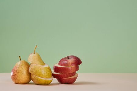 Pear and apple divided on slices. Juicy mellow fruits. Summer harvest. Healthy lifestyle. Copy...