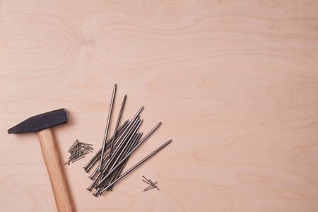 Hammer equipment and different sizes of tacks. Building and renovation concept. Isolated on wooden...