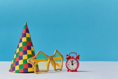 Celebration or Festive event concept. Head cap and glasses. Red clock showing twelve oclock. Fun...