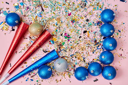 New year celebration. Happy holiday. Xmas party. Blue balls with glitter. Firecrackers with confetti on pink backdropの写真素材