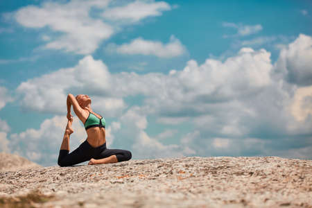 Woman stretching on mountain. Pilates, Yoga or Contemplation. Comfy sportswear for workout. Breathtaking viewの写真素材