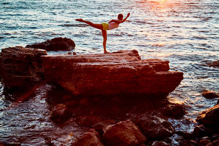 Stretching and pilates on fresh air concept, copy space. Female standing in yoga position. Beautiful...