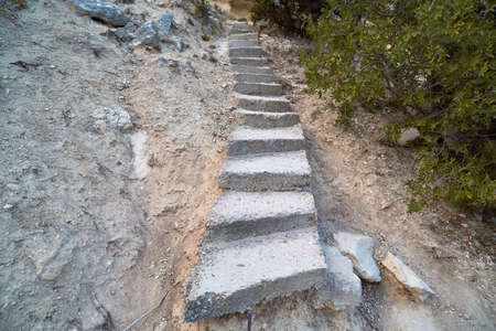 Concrete cement staircase on nature. Lack of roads and steep rise in desert area. Adventure and...