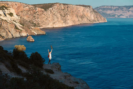 Woman posing on breathtaking mountain and sea view. Lifestyle change or thirst of travel idea. Goal...