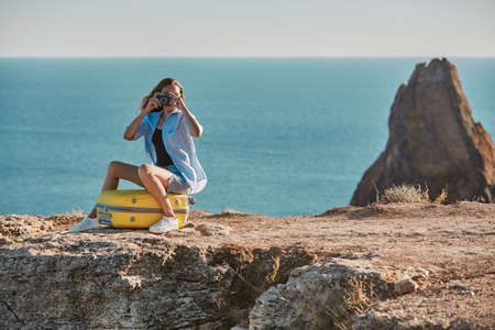 Business travel and new ground concept, copy space. Lady take picture on photocamera sitting on...